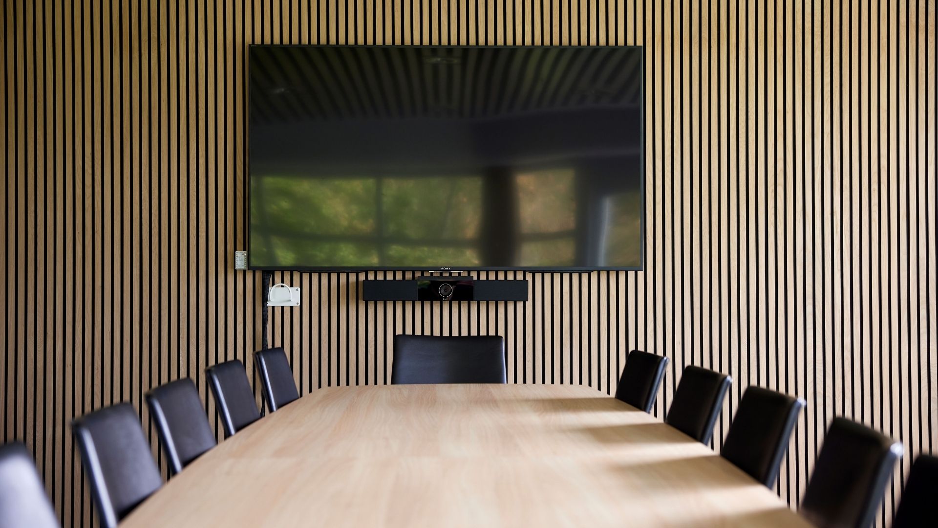 Mødelokale med konferencebord og træpanel
